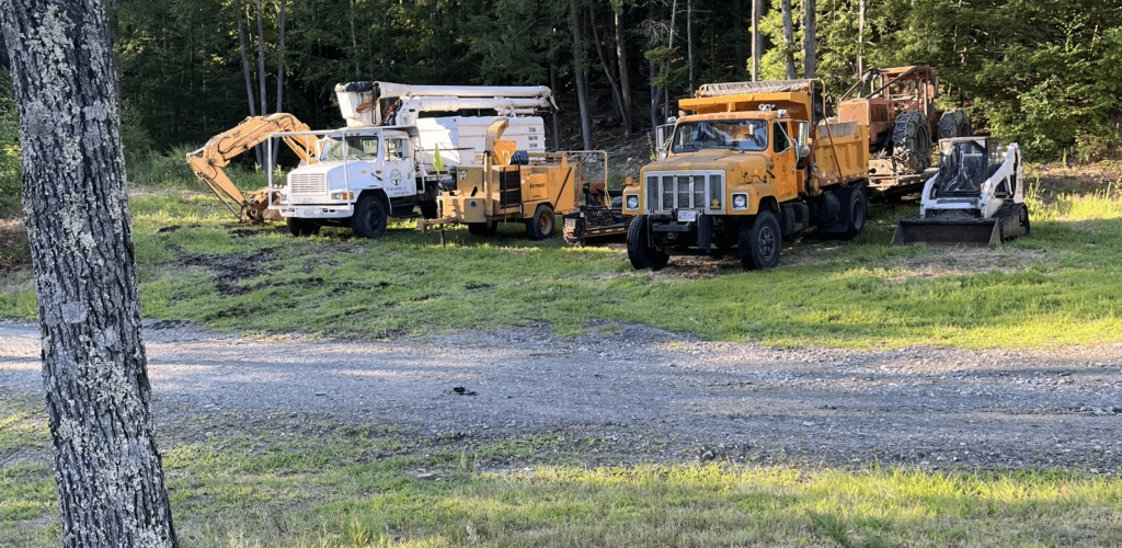 The PV Tree Service fleet of trucks and wood chipper parked on a job site